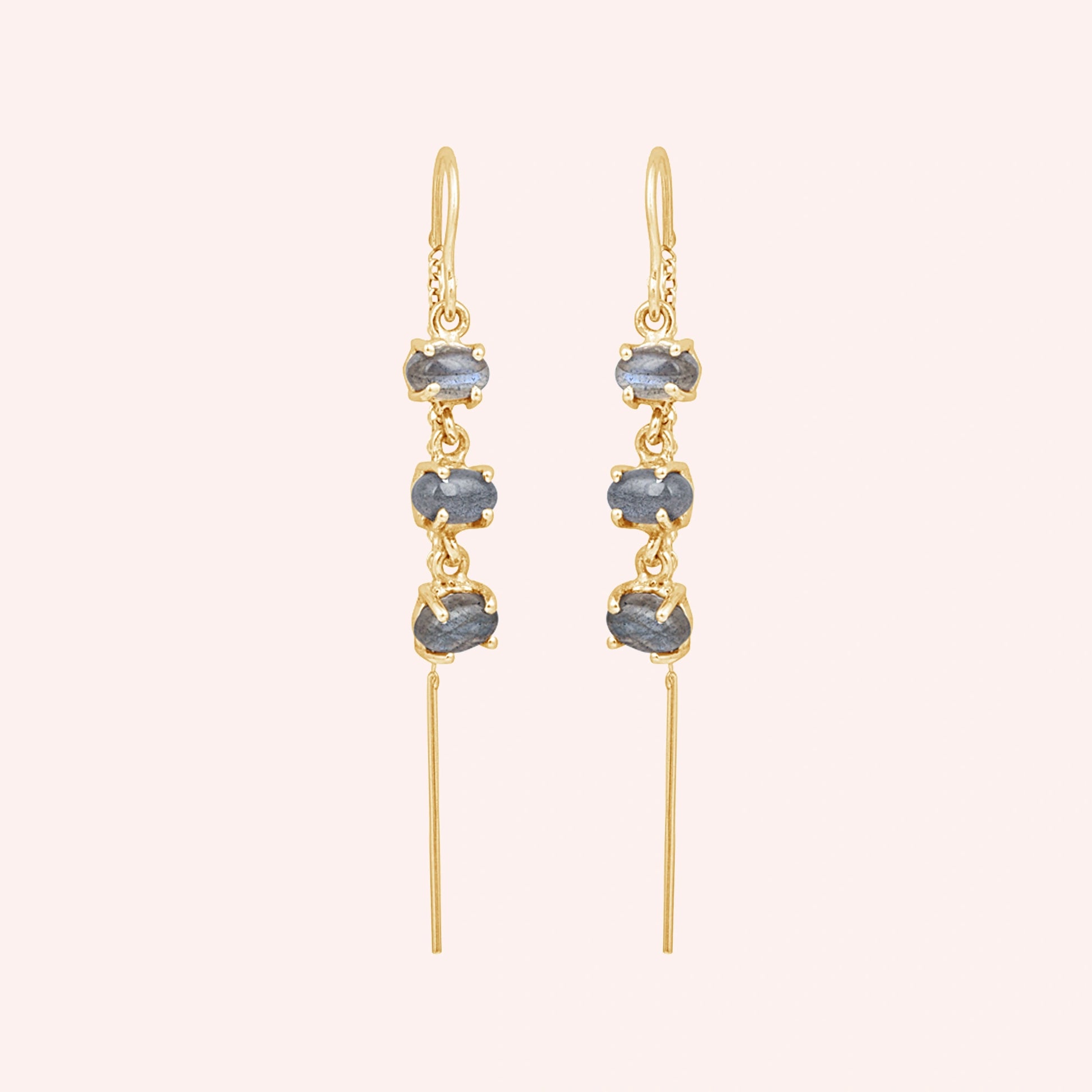 Gold plated threader earrings with a chain design with three linked labradorite stones viewed straight on a light pink background