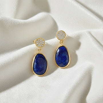 Lapis_lazuli_earrings_in_gold_plated_silver_with_lapis_lazuli_and_cz_stones_in_front_angle_on_a_white_fabric_background
