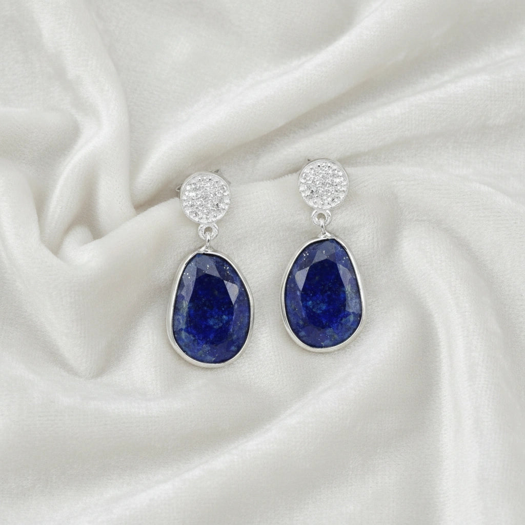 Lapis_lazuli_earrings_in_sterling_silver_with_lapis_lazuli_and_cz_stones_in_front_angle_on_a_white_fabric_background