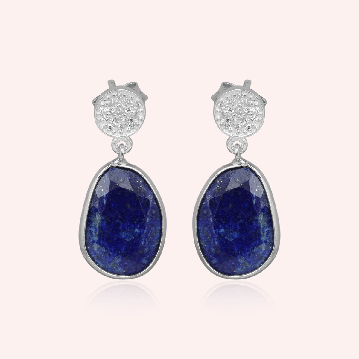 Lapis_lazuli_earrings_in_sterling_silver_with_lapis_lazuli_and_cz_stones_in_front_angle_on_a_solid_pink_background