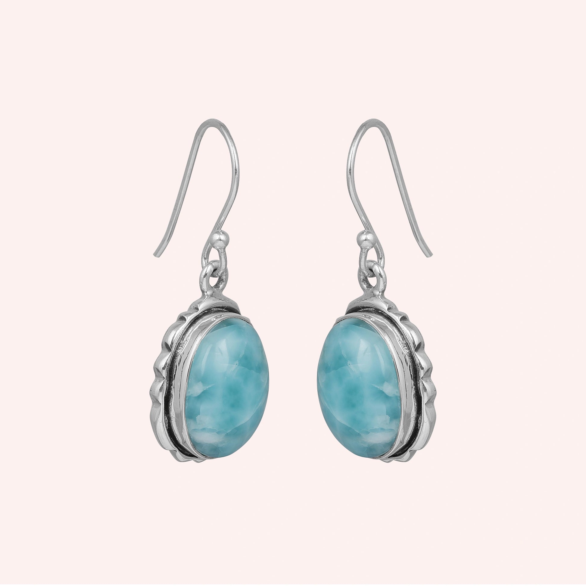 Silver dangling earring sterling silver drop earrings with oval larimar stones on a light pink studio background