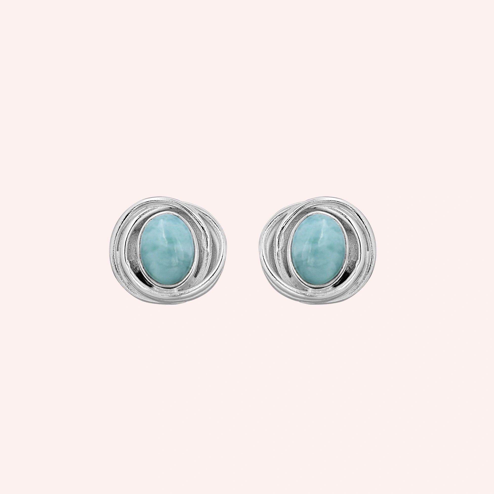 Larimar_earrings_sterling_silver_stud_design_with_oval_larimar_stone_shown_at_front_angle_on_solid_pink_background