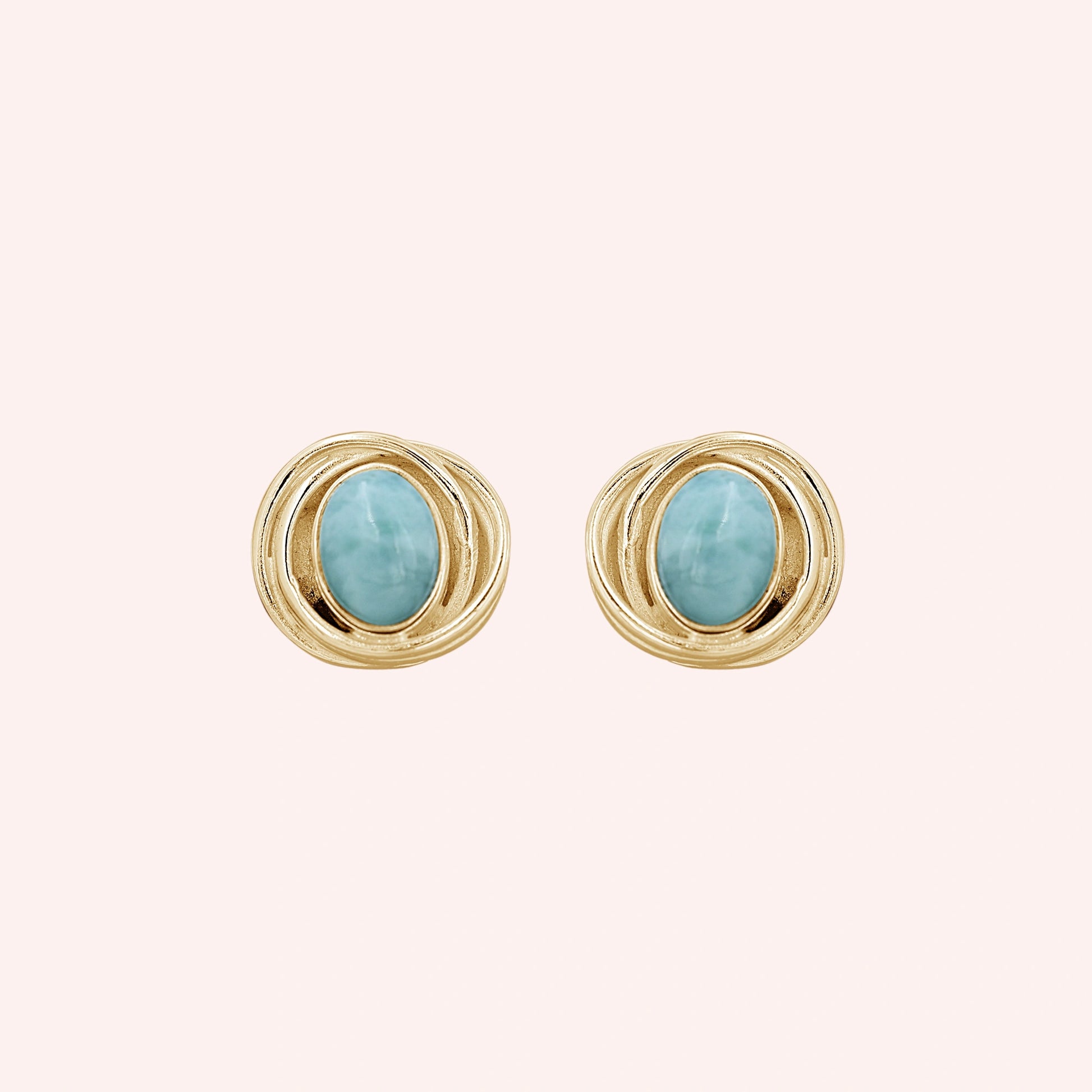 Larimar_earrings_gold_plated_silver_stud_design_with_oval_larimar_stone_shown_at_front_angle_on_solid_pink_background