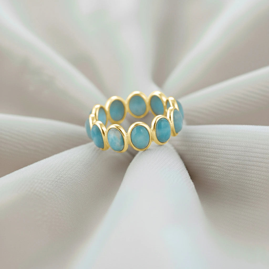 Gold vermeil sterling silver larimar ring photographed at a slight angle on white velvet fabric
