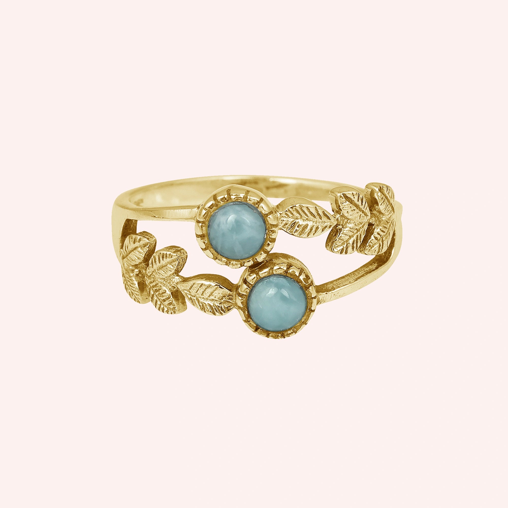 Gold plated sterling silver leaf ring with two larimar stones on light pink background from a straight product view