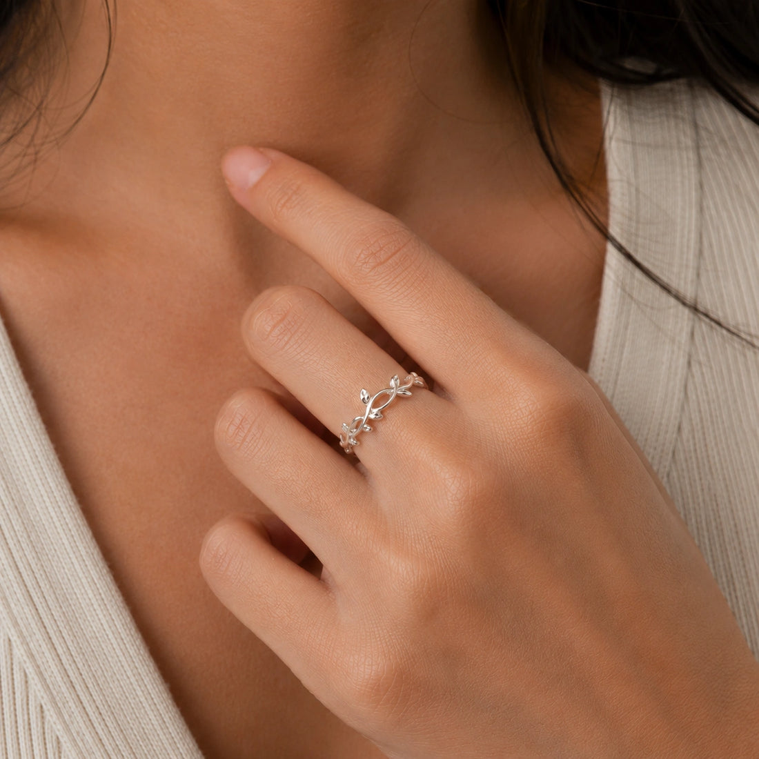 Leaf_ring_in_gold_plated_silver_with_a_floral_design_at_front_angle_on_soft_fabric_background