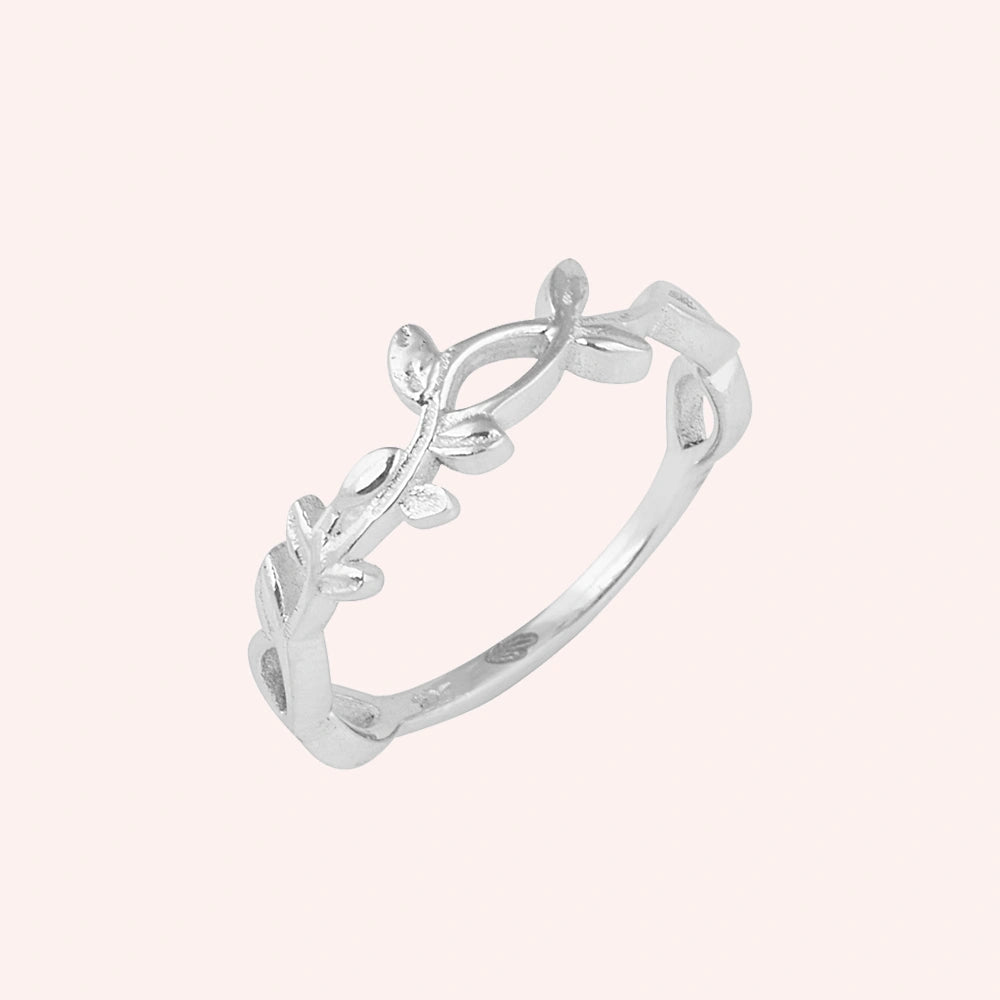 Leaf_ring_in_sterling_silver_with_a_floral_design_at_slight_angle_on_solid_pink_background