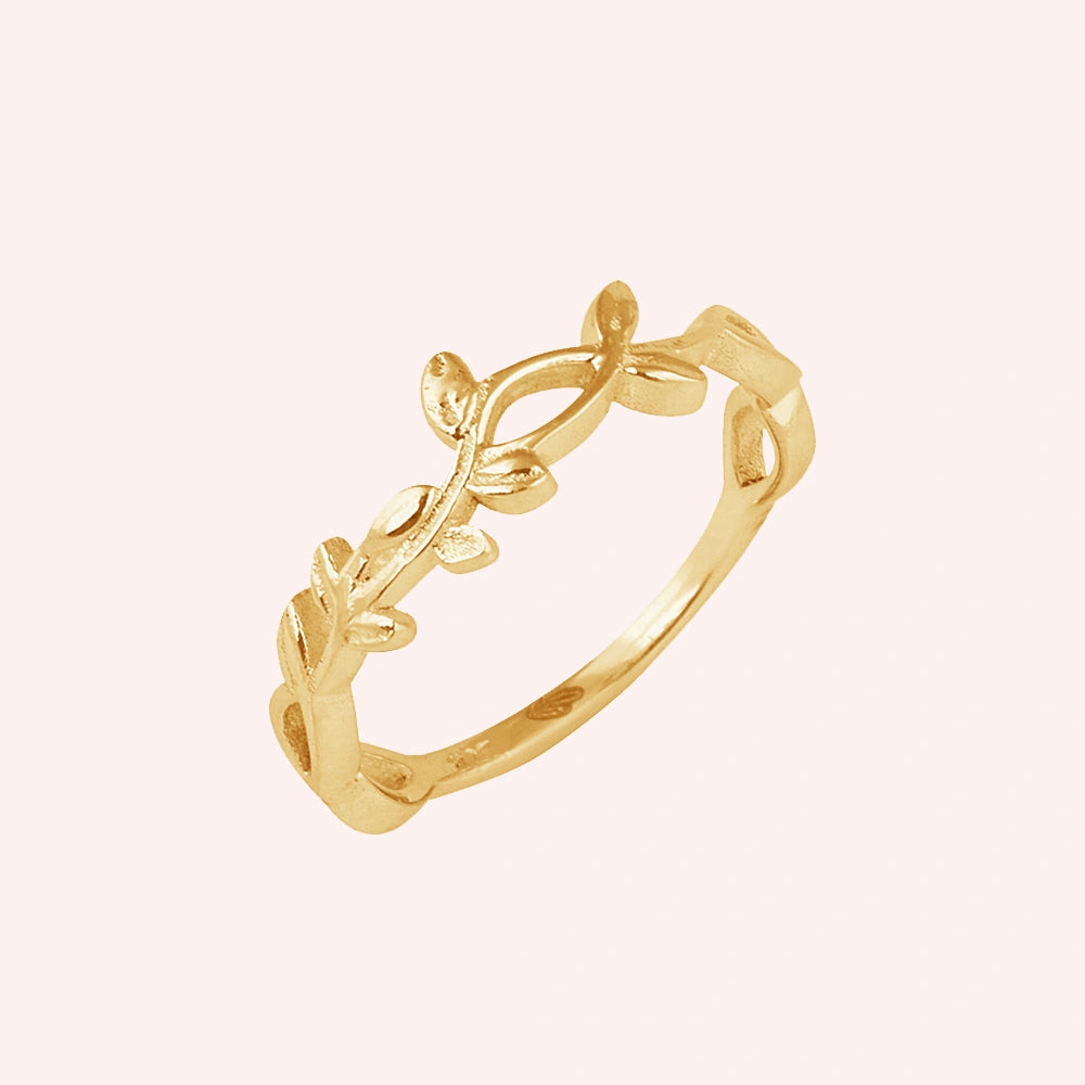 Leaf_ring_in_gold_plated_silver_with_a_floral_design_at_slight_angle_on_solid_pink_background