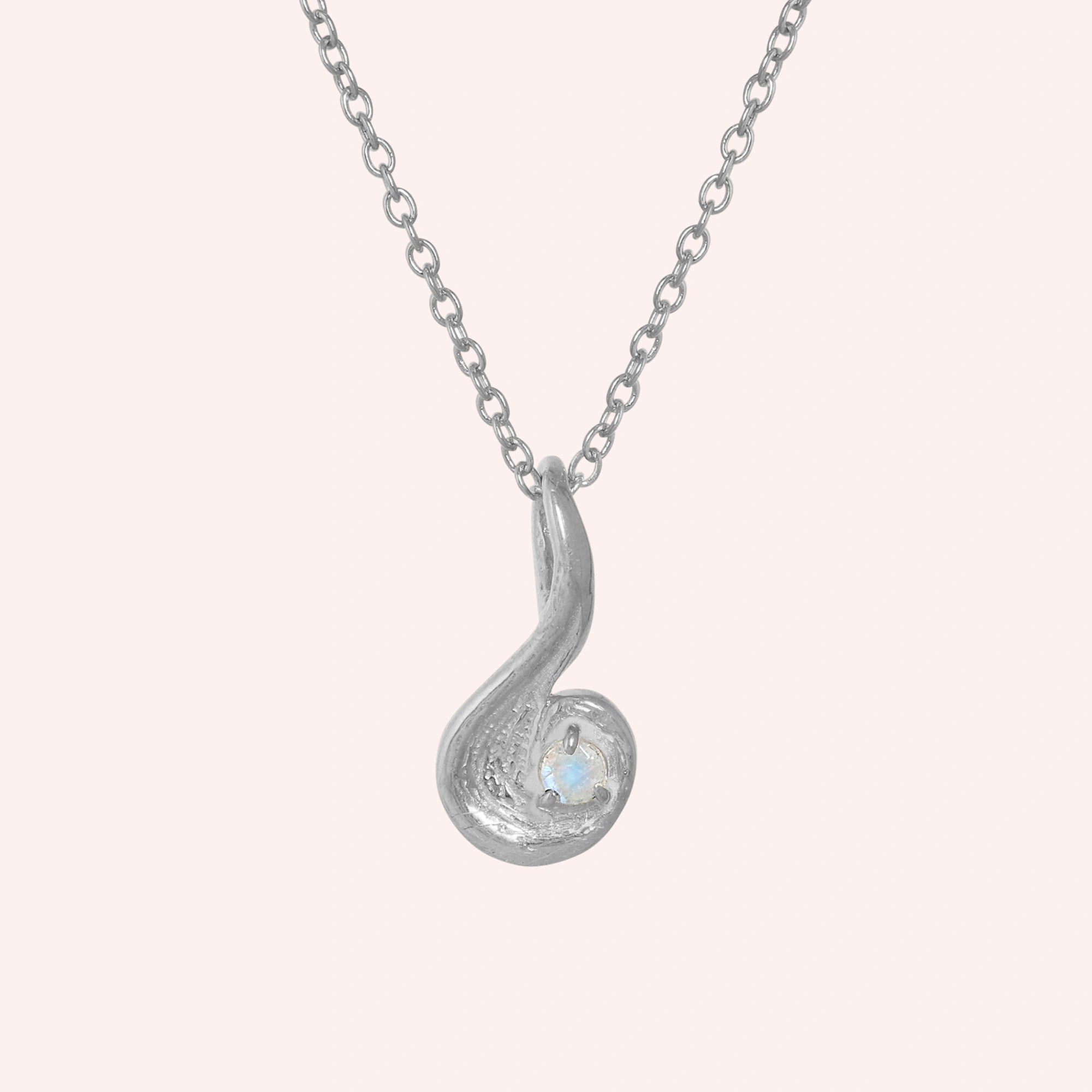 Locket_necklace_with_sterling_silver_teardrop_pendant_and_moonstone_at_front_angle_on_solid_pink_background