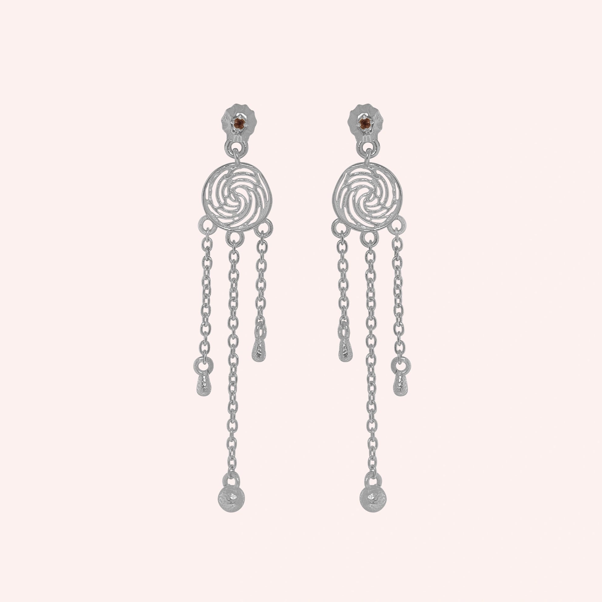 Long_chain_earrings_in_sterling_silver_featuring_smoky_quartz_stone_at_front_angle_on_solid_pink_background