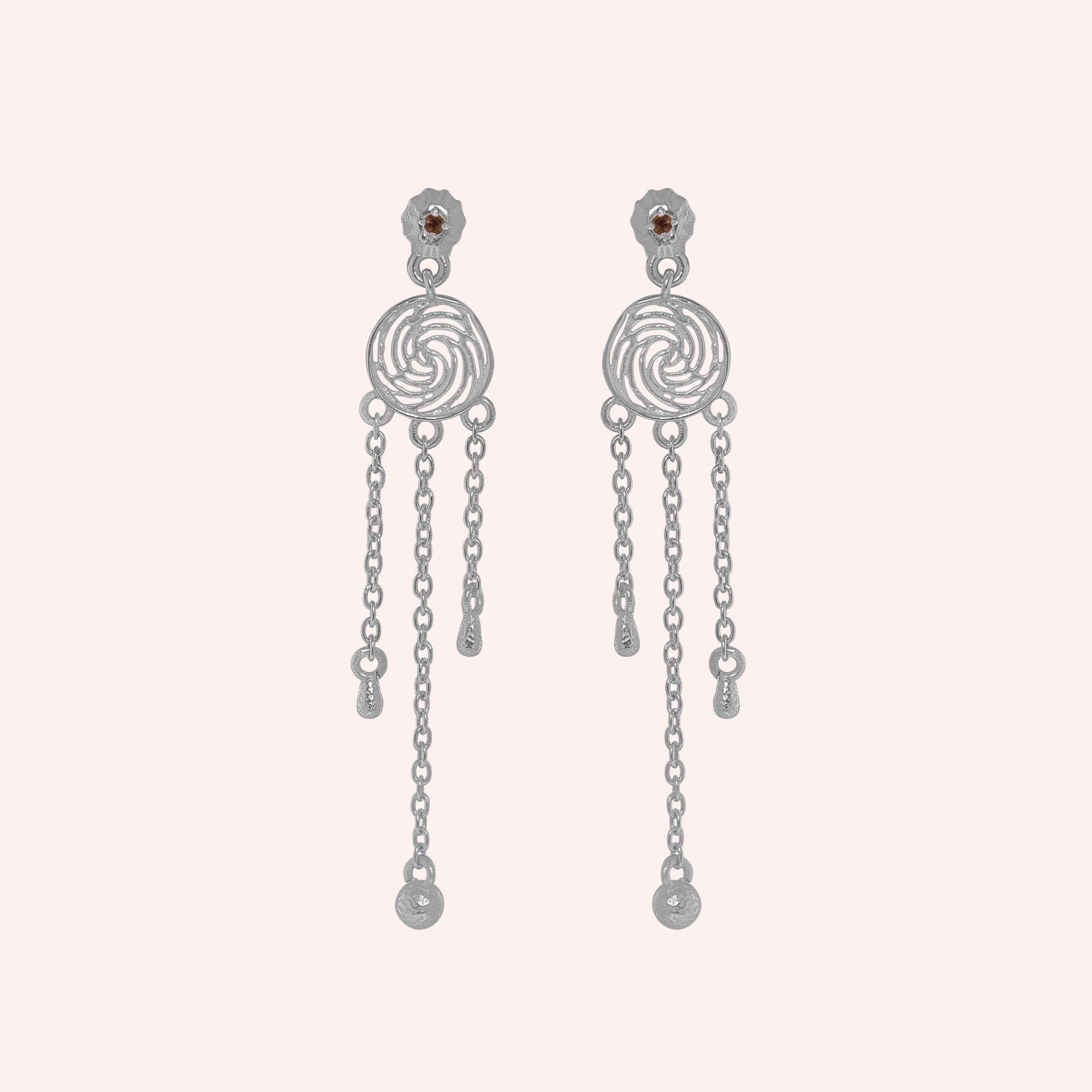 Long_chain_earrings_in_sterling_silver_featuring_smoky_quartz_stone_at_front_angle_on_solid_pink_background