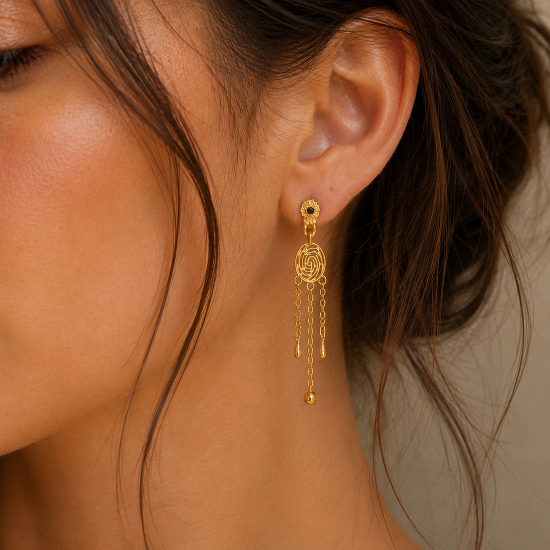 Long_chain_earrings_in_gold_plated_silver_featuring_smoky_quartz_stone_at_front_angle_on_soft_fabric_background