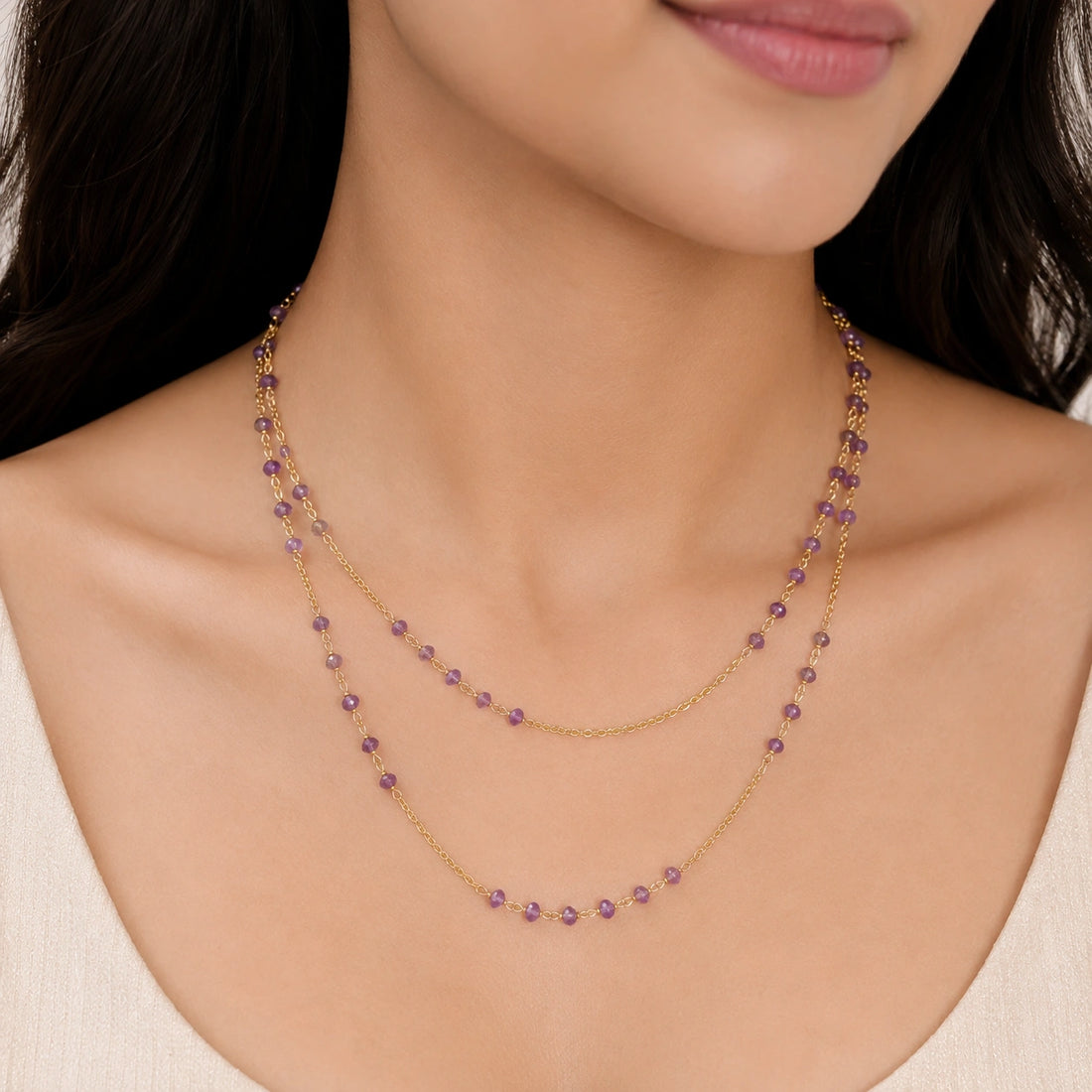 Long_chain_necklace_in_gold_plated_silver_with_amethyst_beads_at_front_angle_view_on_soft_fabric_background