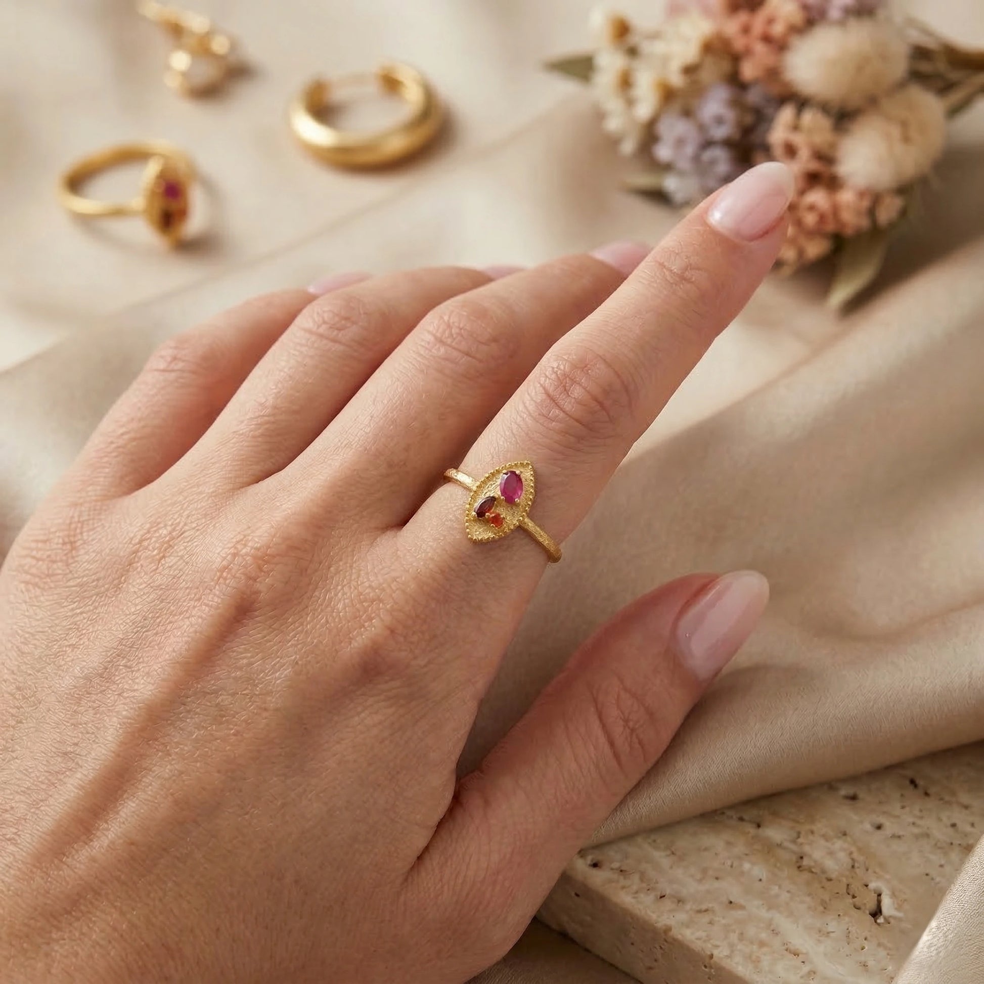 Marquise-ring-with-ruby-garnet-and-carnelian-stones-worn-on-a-model-hand-in-a-natural-light