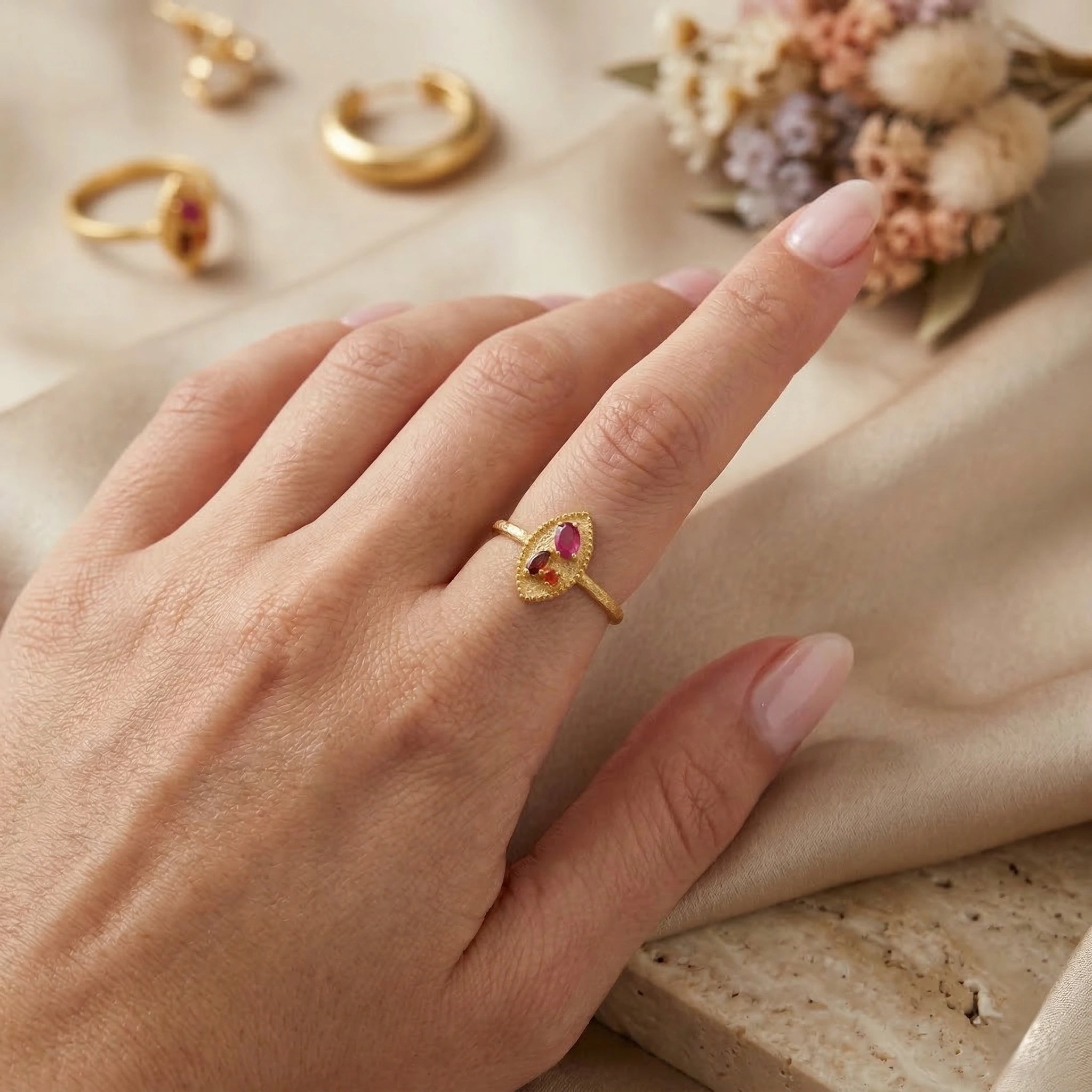 Marquise-ring-with-ruby-garnet-and-carnelian-stones-worn-on-a-model-hand-in-a-natural-light