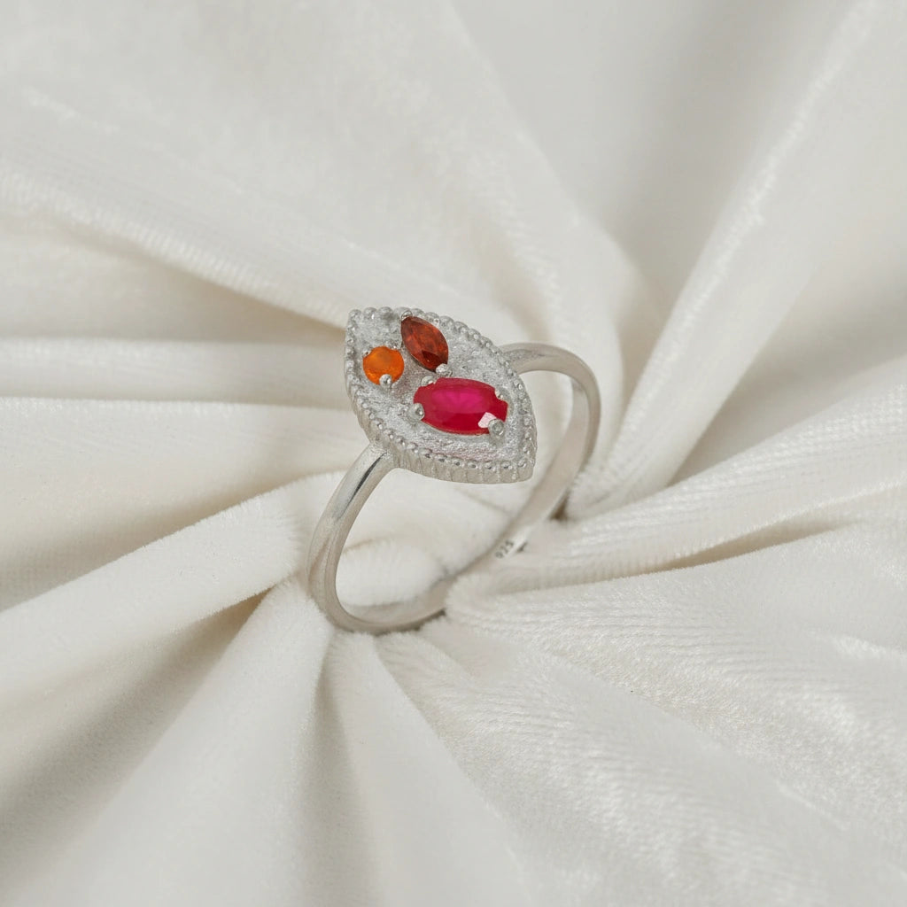 Marquise-ring-with-ruby-garnet-and-carnelian-stones-sterling-silver-angled-view-on-white-satin-background