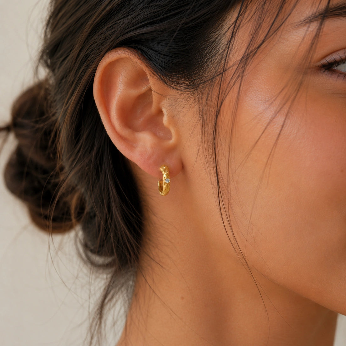 Mini_hoop_earrings_gold_plated_silver_hoop_design_with_moonstone_in_side_angle_view_on_soft_fabric_background