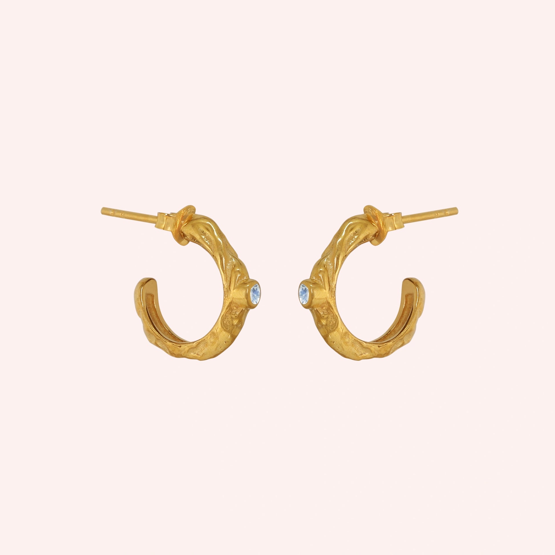 Mini_hoop_earrings_gold_plated_silver_hoop_design_with_moonstone_in_side_angle_view_on_solid_pink_background