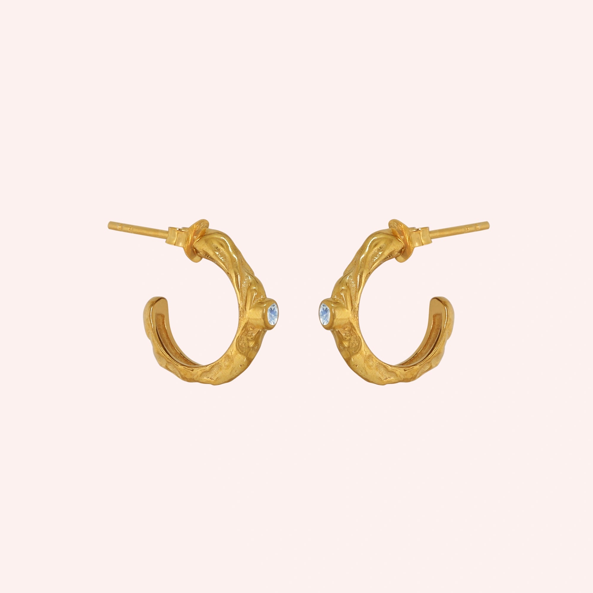 Mini_hoop_earrings_gold_plated_silver_hoop_design_with_moonstone_in_side_angle_view_on_solid_pink_background