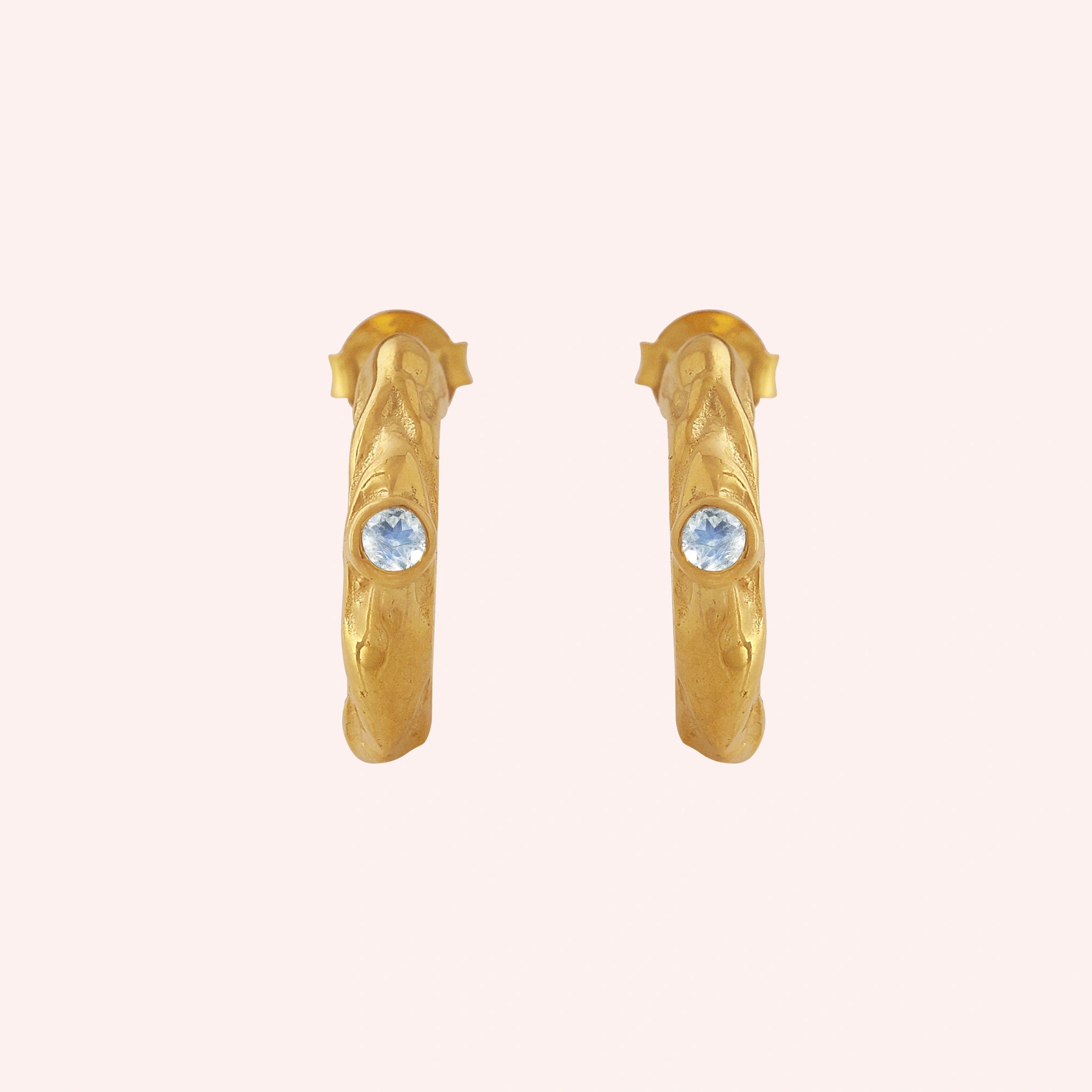 Mini_hoop_earrings_gold_plated_silver_hoop_design_with_moonstone_in_front_angle_view_on_solid_pink_background
