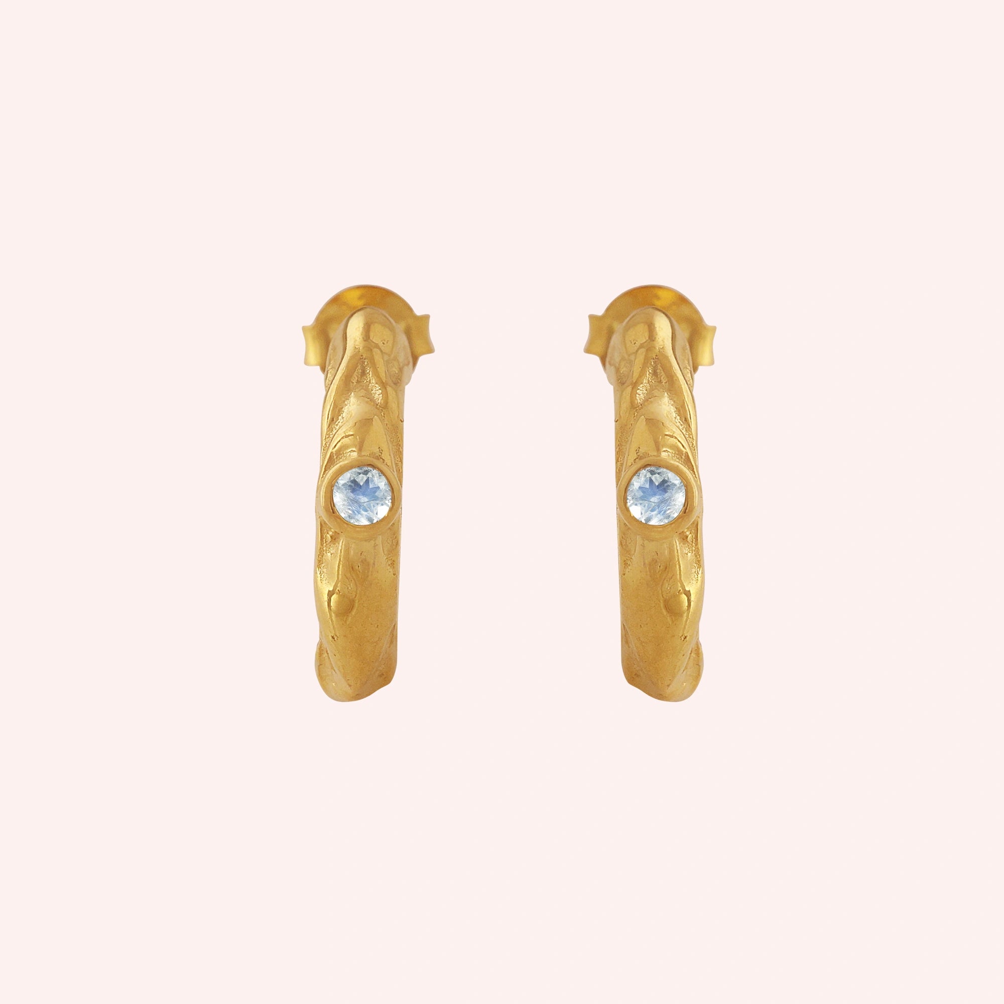 Mini_hoop_earrings_gold_plated_silver_hoop_design_with_moonstone_in_front_angle_view_on_solid_pink_background