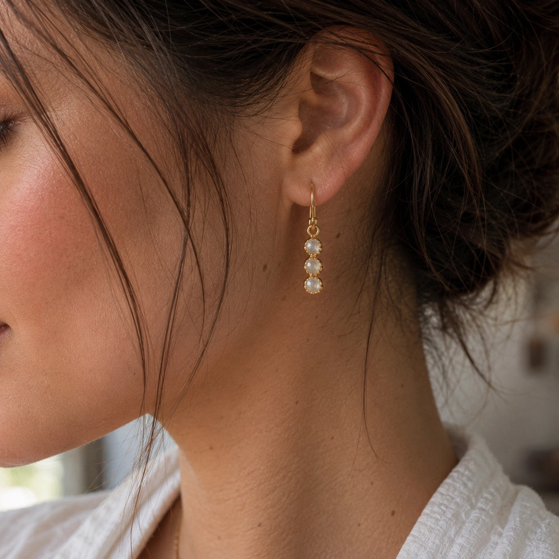 Minimal_earrings_in_gold_plated_silver_at_slightly_angled_featuring_moonstone_drops_on_a_soft_fabric_background
