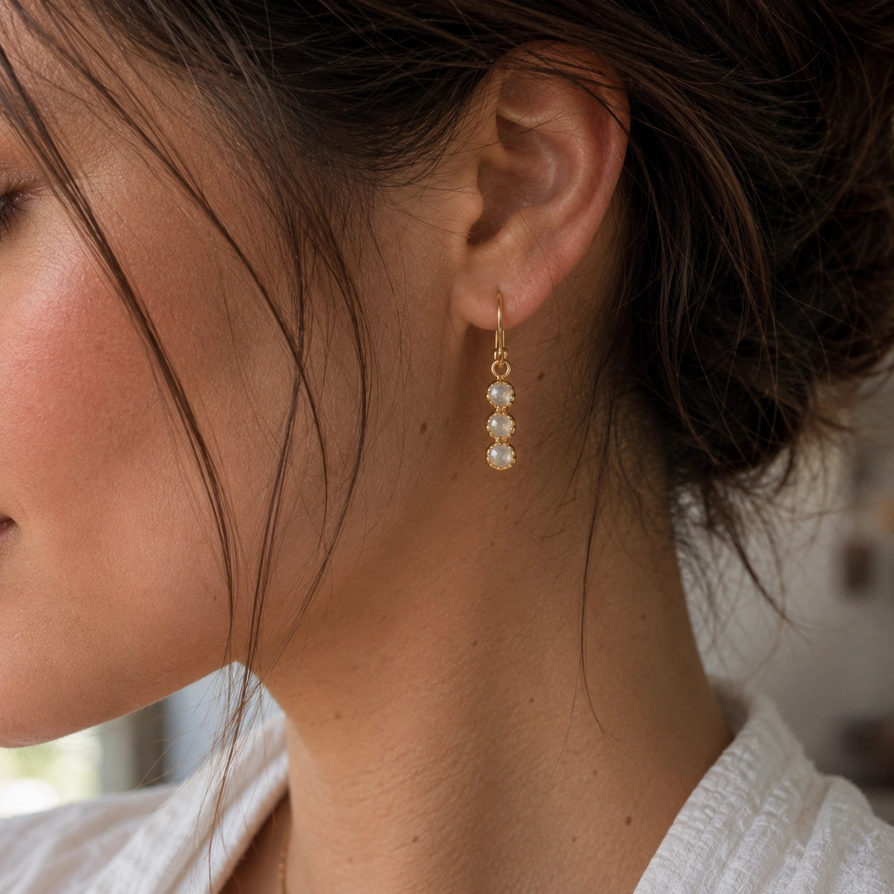Minimal_earrings_in_gold_plated_silver_featuring_moonstone_drops_worn_by_a_model