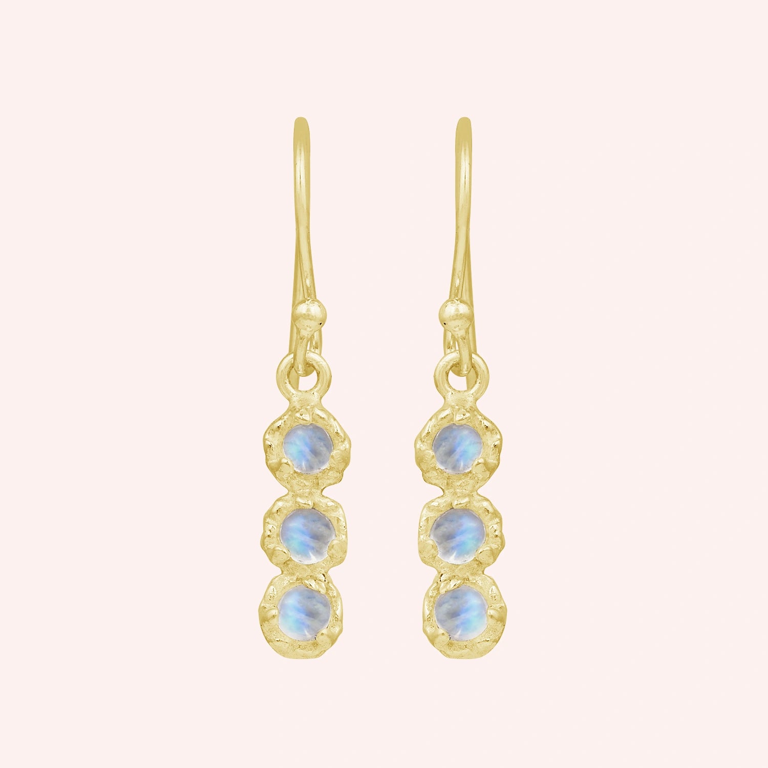 Minimal_earrings_in_gold_plated_silver_at_front_angle_featuring_moonstone_drops_on_a_solid_pink_background