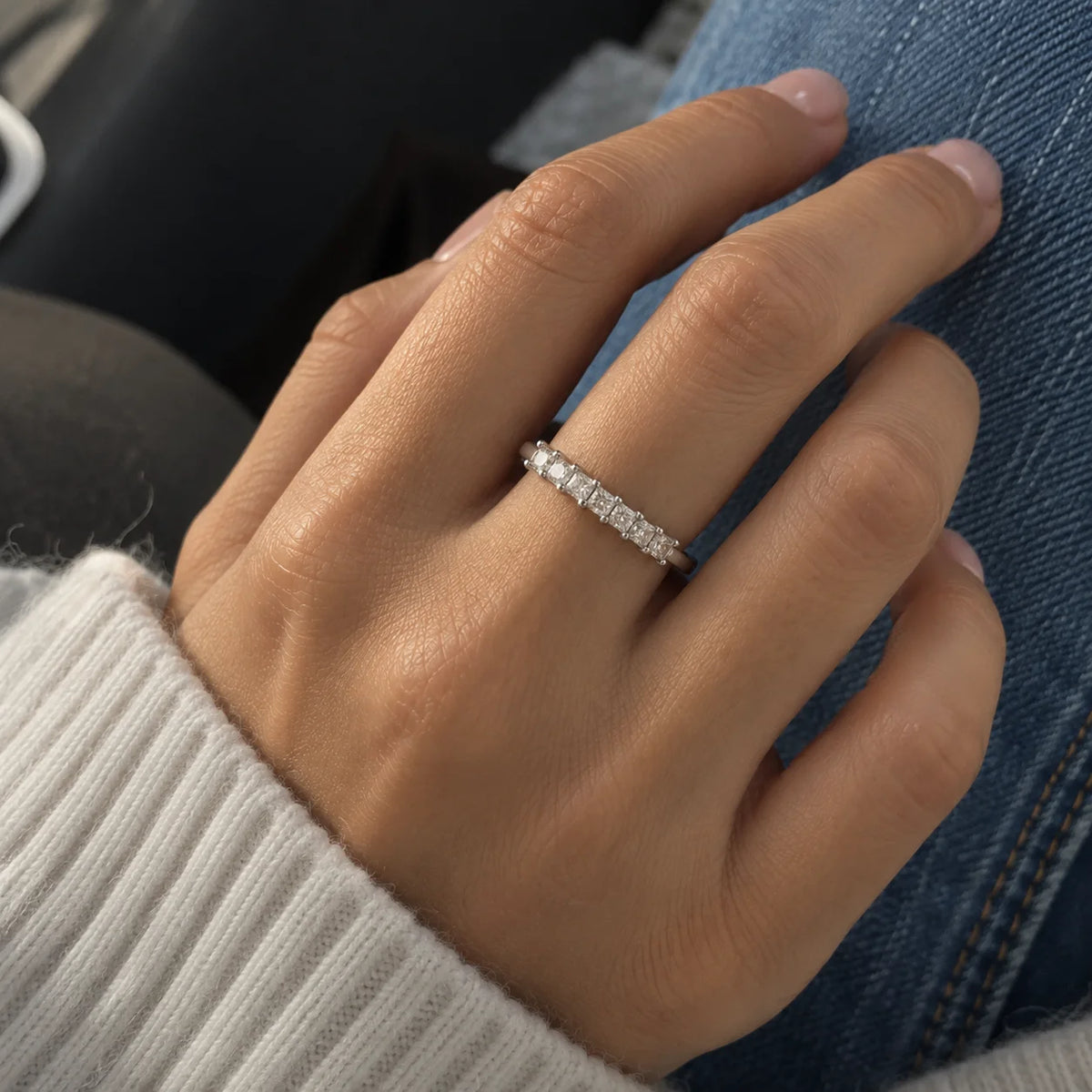 Minimal_ring_in_sterling_silver_with_square_cut_CZ_stones_at_front_angle_view_worn_by_a_model