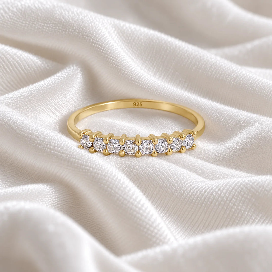 Minimal_ring_in_gold_plated_silver_with_square_cut_lab_grown_diamonds_at_front_angle_view_on_soft_fabric_background