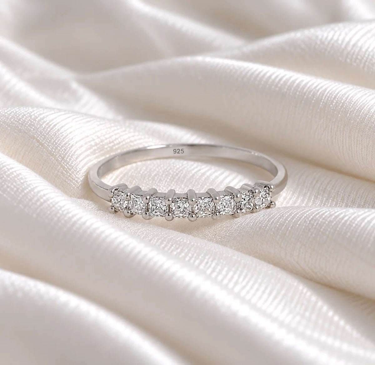 Minimal_ring_in_sterling_silver_with_square_cut_lab_grown_diamonds_at_front_angle_view_on_soft_fabric_background