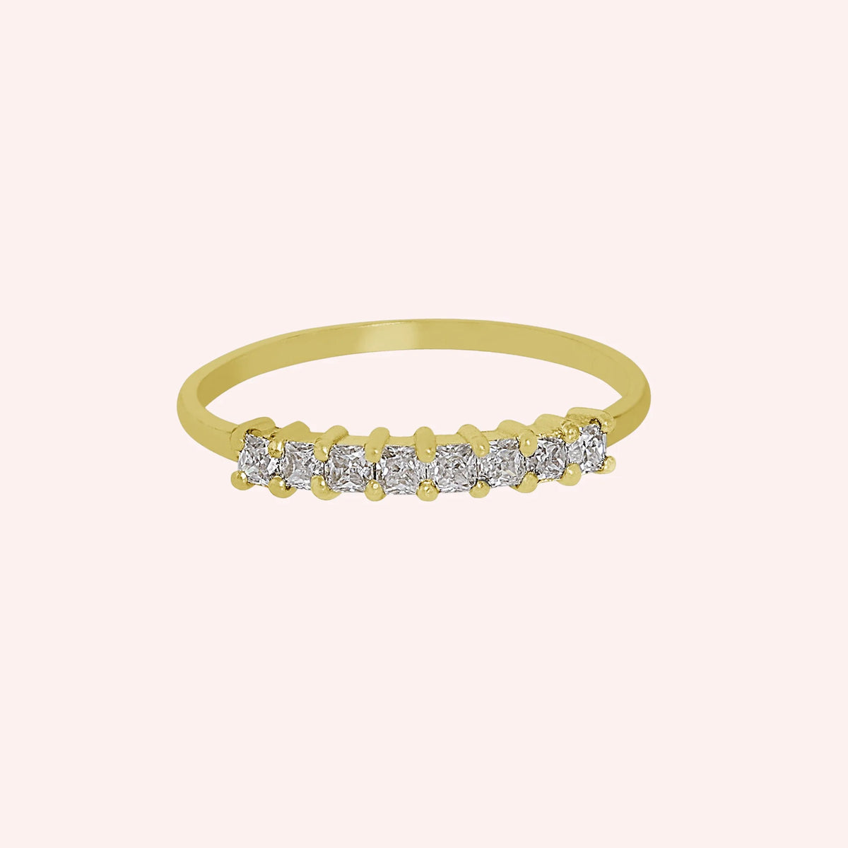 Minimal_ring_in_gold_plated_silver_with_square_cut_CZ_stones_at_front_angle_view_on_solid_pink_background