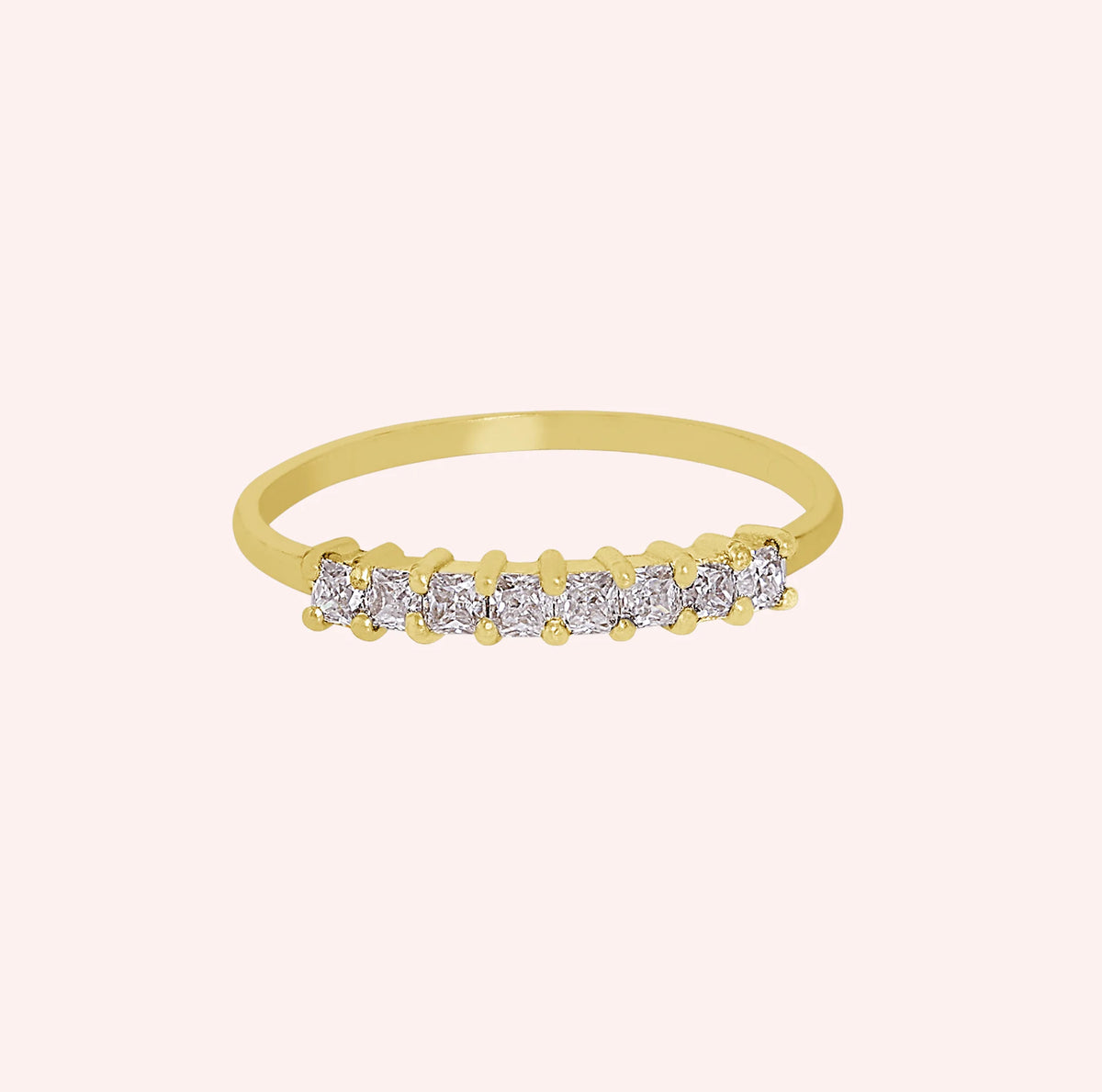 Minimal_ring_in_gold_plated_silver_with_square_cut_lab_grown_diamonds_at_front_angle_view_on_solid_pink_background