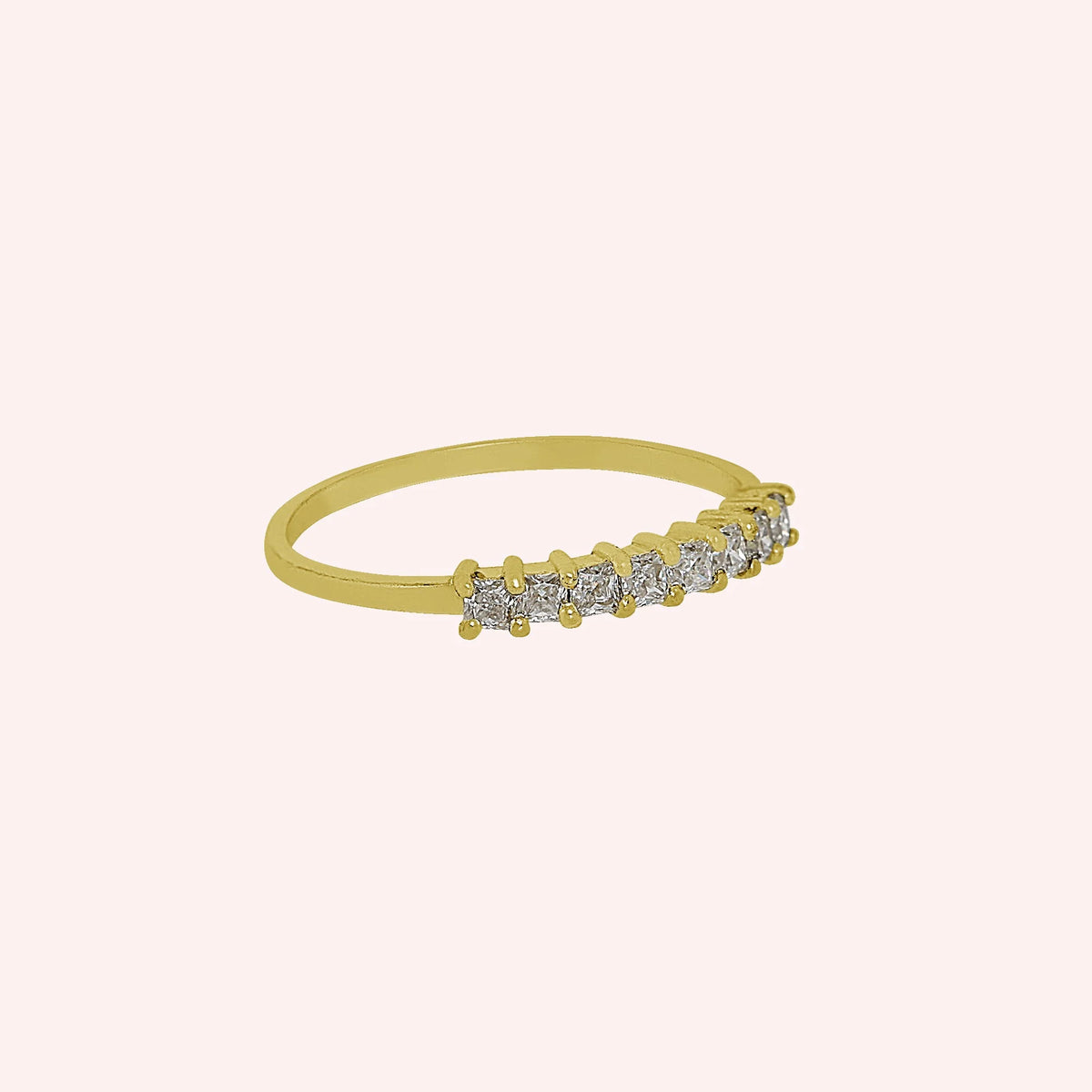Minimal_ring_in_gold_plated_silver_with_square_cut_CZ_stones_at_side_angle_view_on_solid_pink_background