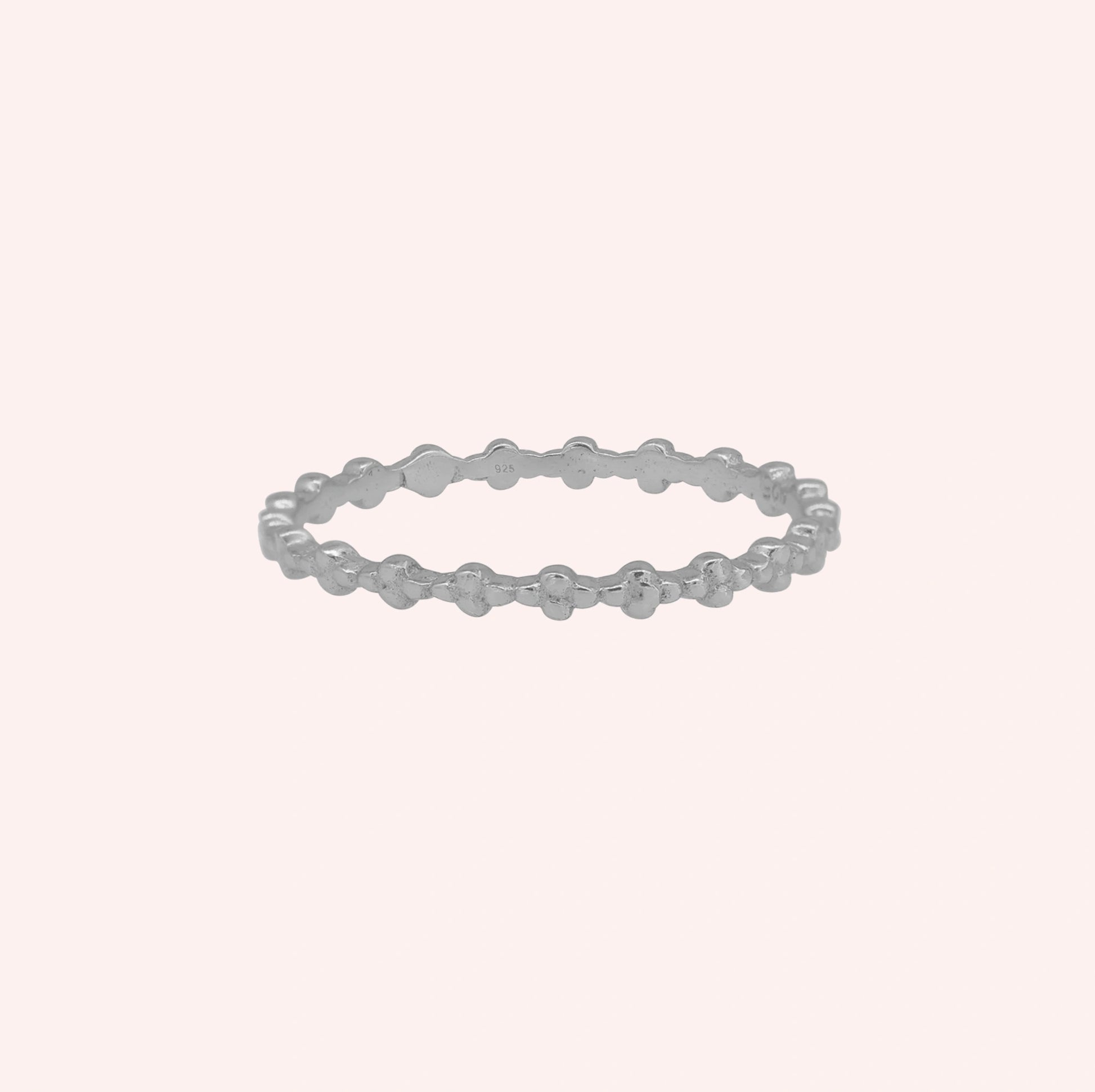 Minimal_ring_in_sterling_silver_at_front_angle_on_solid_pink_background