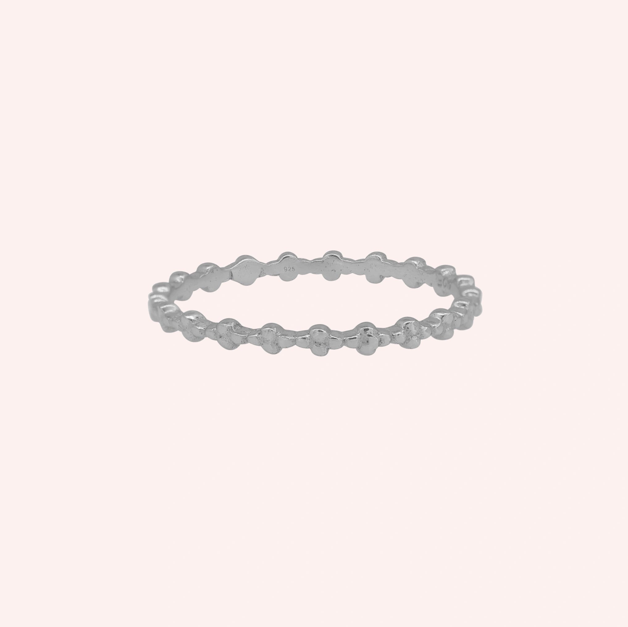 Minimal_ring_in_sterling_silver_at_front_angle_on_solid_pink_background