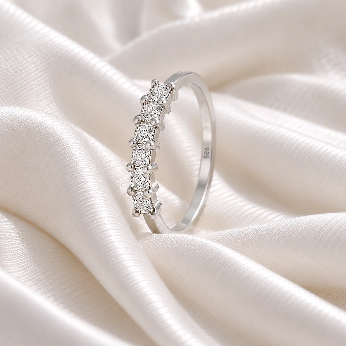Minimal_ring_in_sterling_silver_with_square_cut_lab_grown_diamonds_at_side_angle_view_on_soft_fabric_background