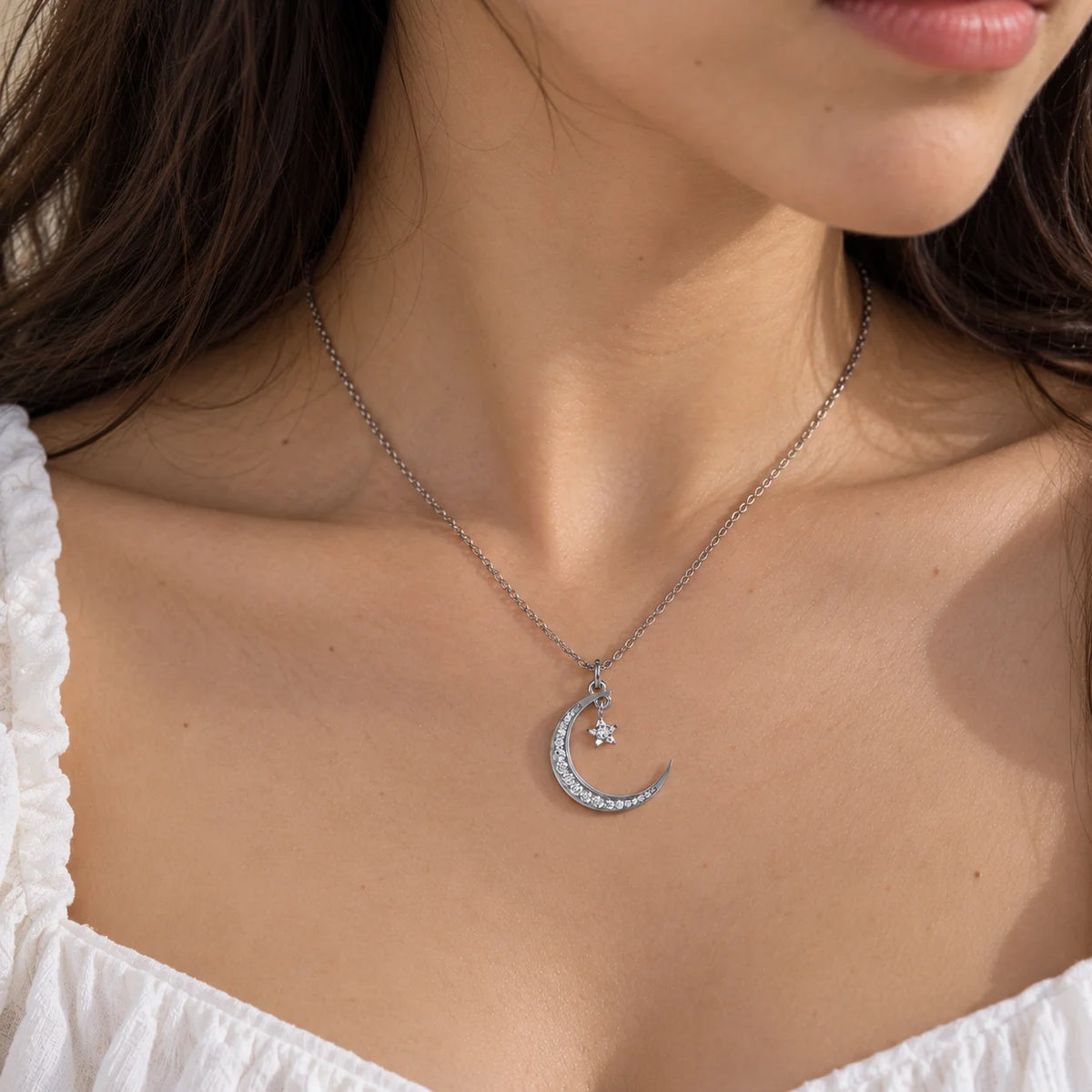 Moon_necklace_in_sterling_silver_with_a_small_star_charm_worn_by_a_model