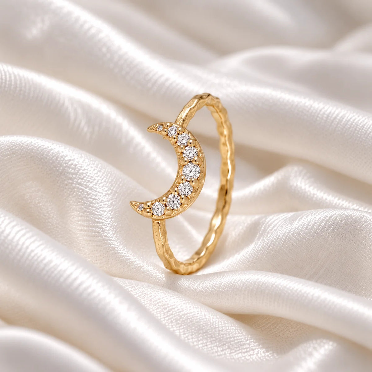 Moon_ring_in_gold_plated_silver_with_a_crescent_moon_design_at_side_angle_view_on_soft_fabric_background