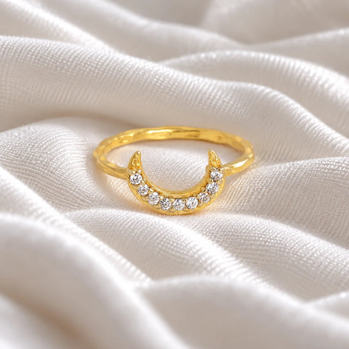 Moon_ring_in_gold_plated_silver_with_a_crescent_moon_design_at_front_angle_view_on_soft_fabric_background