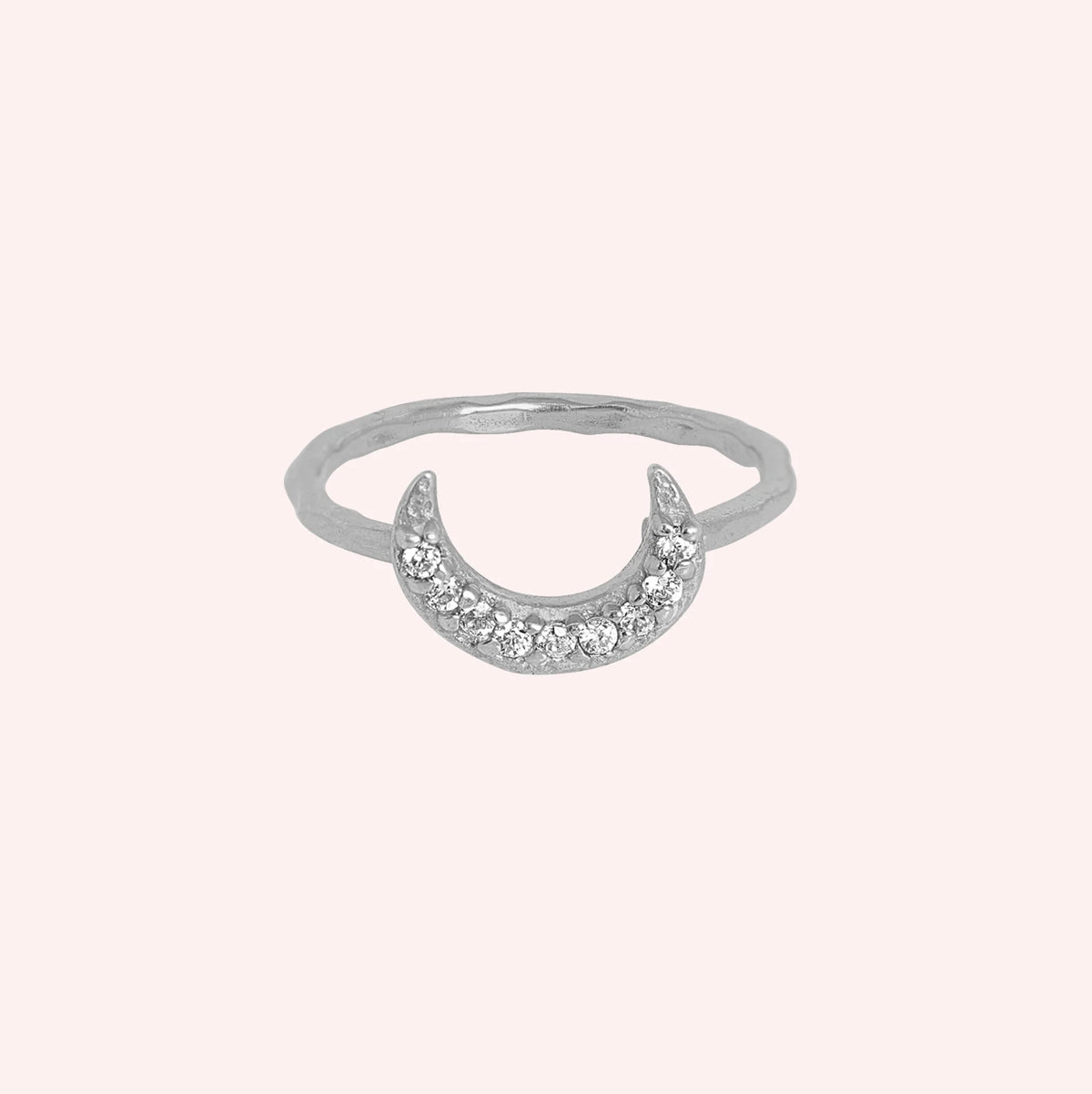 Moon_ring_in_sterling_silver_with_a_crescent_moon_design_at_front_angle_view_on_soli_pink_background