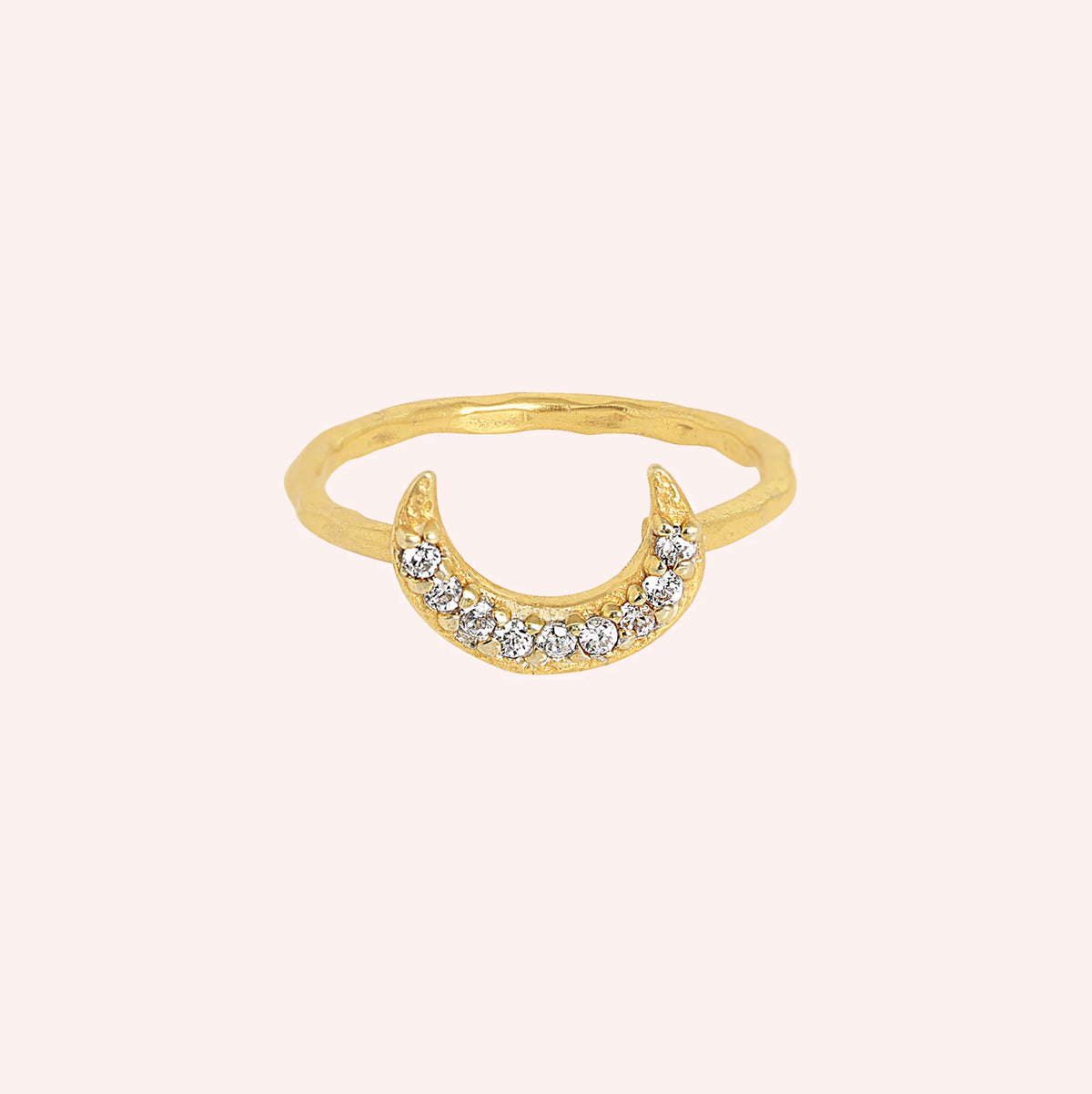 Moon_ring_in_gold_plated_silver_with_a_crescent_moon_design_at_front_angle_view_on_soli_pink_background