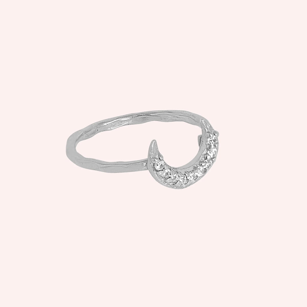 Moon_ring_in_sterling_silver_with_a_crescent_moon_design_at_side_angle_view_on_soli_pink_background
