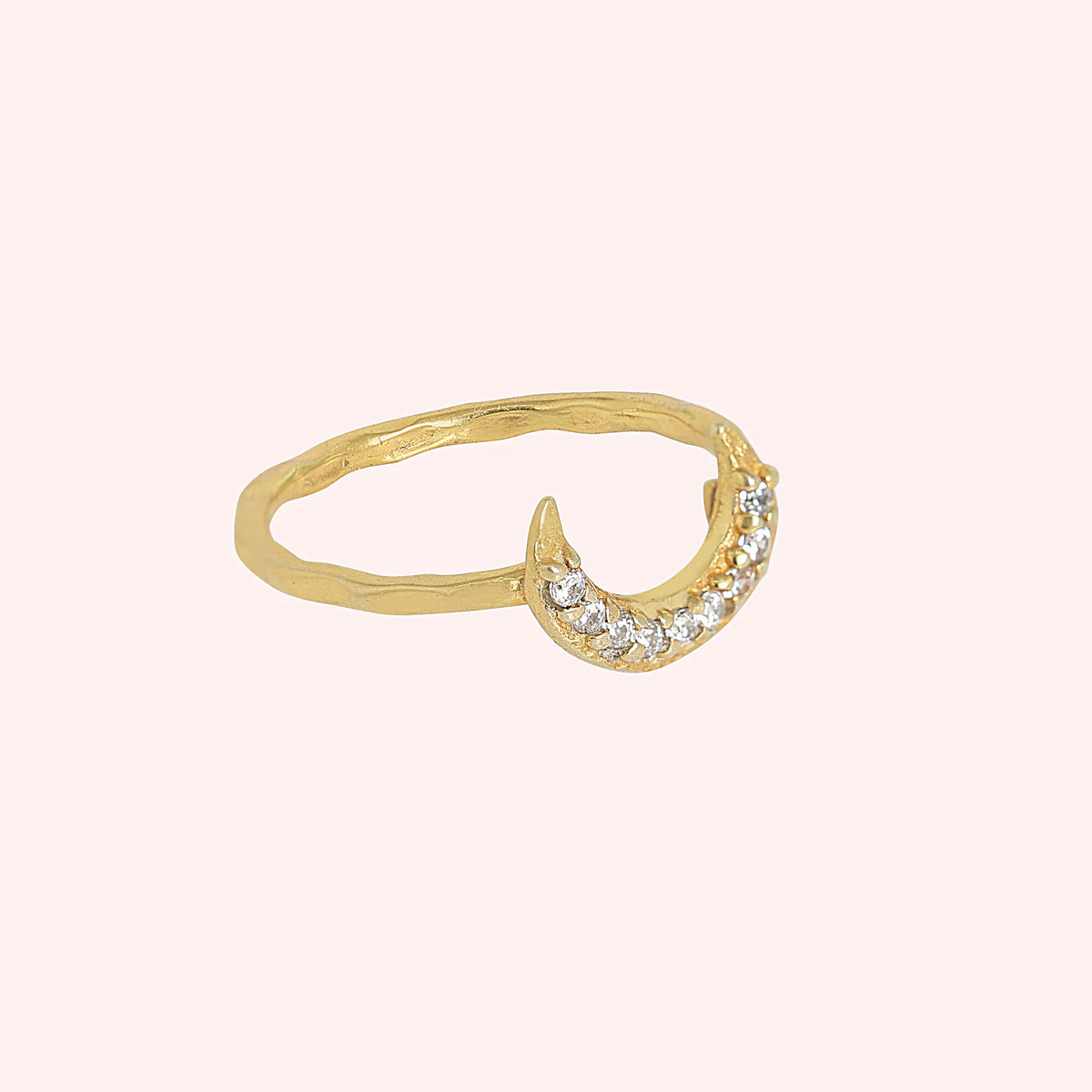 Moon_ring_in_gold_plated_silver_with_a_crescent_moon_design_at_side_angle_view_on_soli_pink_background