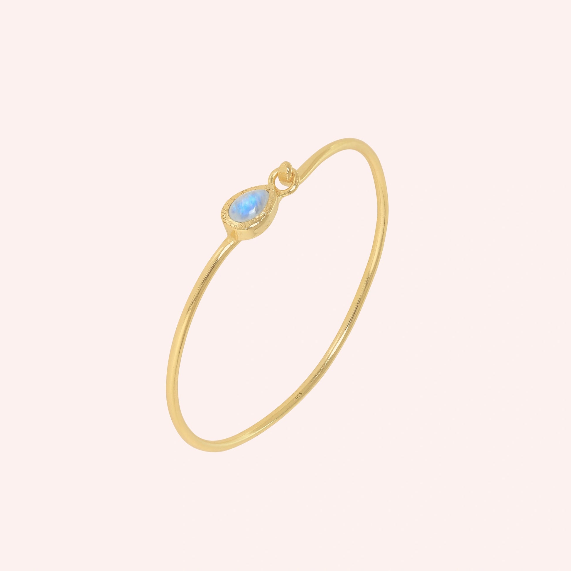 Moonstone_bracelet_in_gold_plated_silver_with_teardrop_moonstone_at_slight_angle_view_on_solid_pink_background