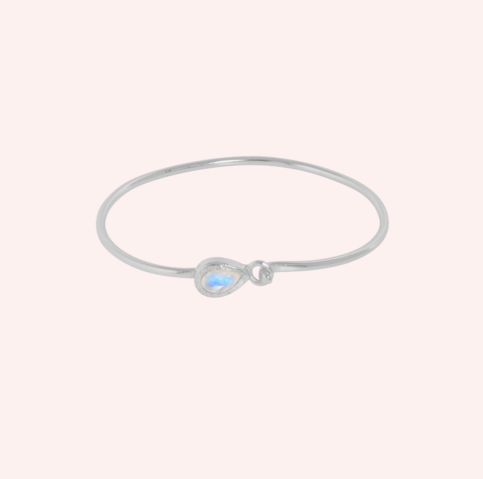 Moonstone_bracelet_in_sterling_silver_with_teardrop_moonstone_at_front_angle_view_on_solid_pink_background