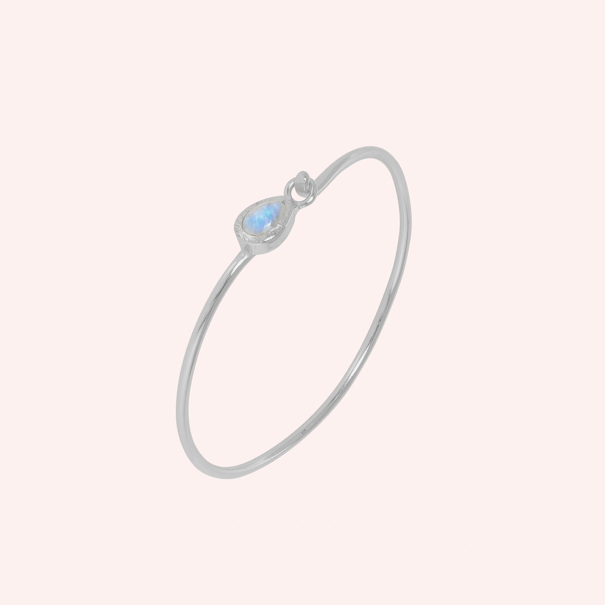Moonstone_bracelet_in_sterling_silver_with_teardrop_moonstone_at_slight_angle_view_on_solid_pink_background