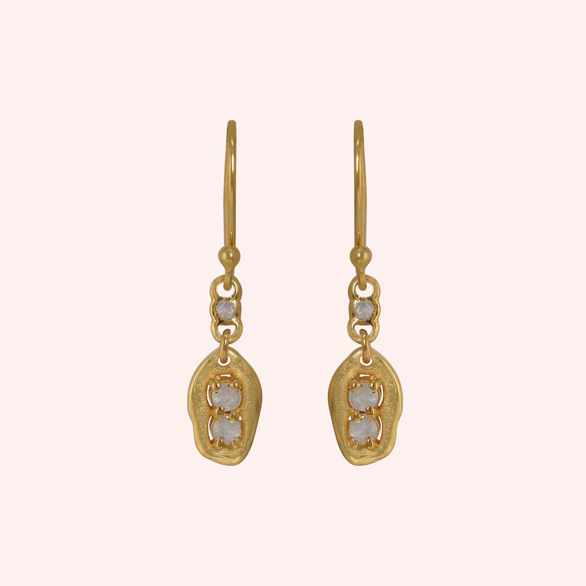 Moonstone_earrings_gold_plated_silver_drop_design_with_three_moonstones_in_front_angled_view_on_solid-pink_background