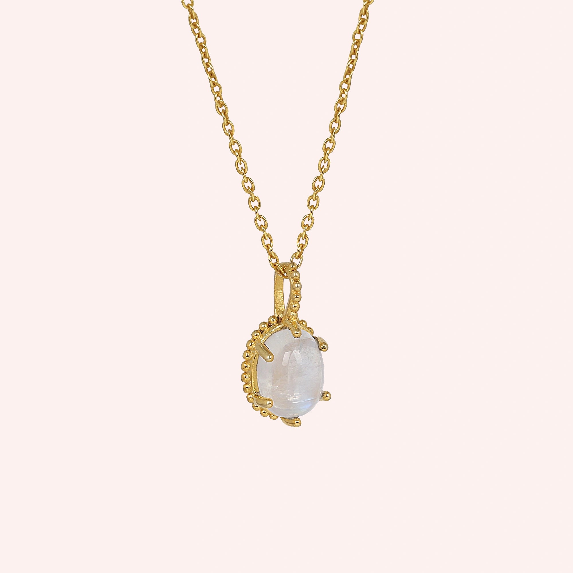 Moonstone_necklace_in_gold_plated_silver_and_glowing_moonstone_in_slightly_angled_view_on_solid_pink_background