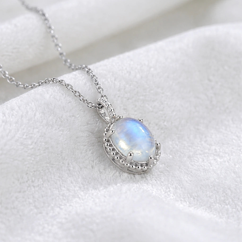 Moonstone_necklace_in_sterling_silver_and_glowing_moonstone_in_slightly_angled_view_on_soft_white_fabric_background